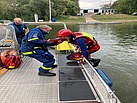 Ein THW Helfer hilft einem Strömungsretter an Bord des MzAB
