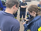 Eine Frau hält eine Steuereinheit in der Hand. Neben ihr steht ein Mann, der auf die Steuereinheit schaut.