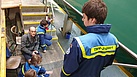 Jugendliche in Einsatzkleidung des Technischen Hilfswerks besuchen die Drachenfelsbahn in Königswinter und lassen sich vom Geschäftsführer den Betrieb erklären.