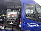 Ein Transporter hat die Schiebetür offen stehen. Darin steht ein Monitor.